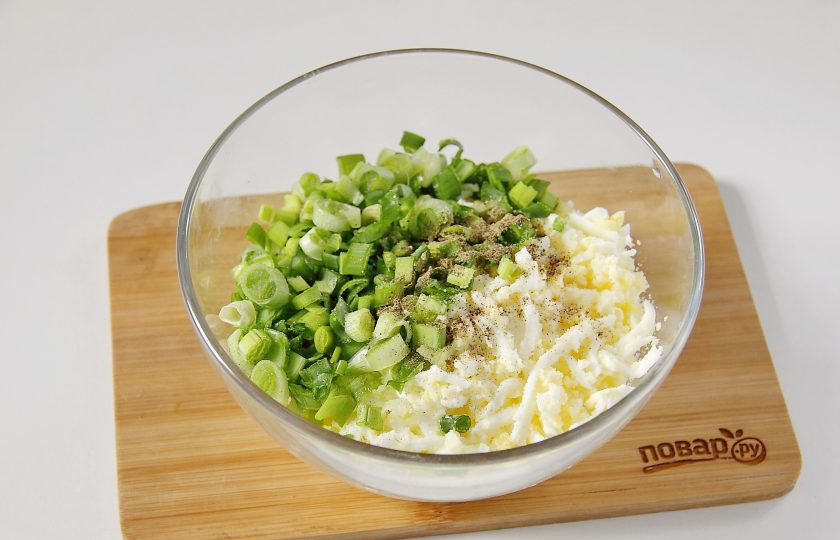 1. Этап. Заливной пирог на кефире с яйцом: Для начинки вареные яйца очистите и натрите на крупной терке. Добавьте измельченный зеленый лук, соль и перец по вкусу.