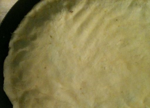 1. Этап. Быстрый луковый пирог: 3. Возьмите сковородку. Тесто переложите на дно сковородки. Аккуратно руками расправьте его так, чтобы края заходили на бортики сковороды. Включите для разогрева духовку.