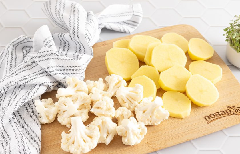 1. Этап. Цветная капуста с картошкой в духовке: Цветную капусту помойте, разберите на небольшие соцветия. Картофель помойте, очистите от кожуры, порежьте кружочками или ломтиками.