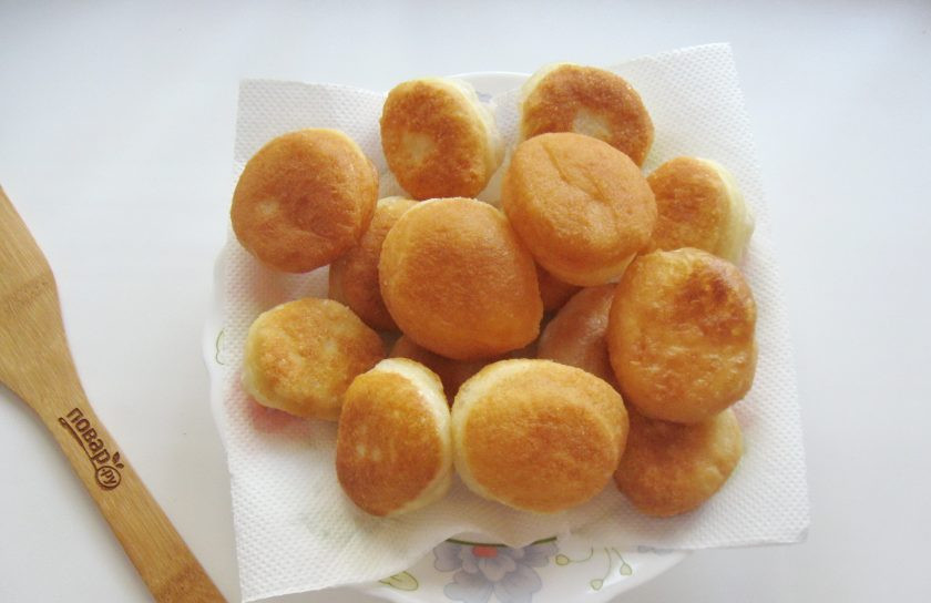 1. Этап. Пончики Бомболони: В каждом пончике сделайте надрез сбоку и с помощью чайной ложки наполните пончики заварным кремом.