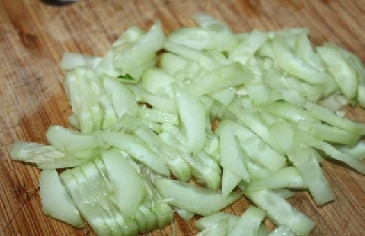 1. Этап. Салат с пророщенной пшеницей: Огурец помойте, очистите от кожуры и нарежьте тонкими полосками.