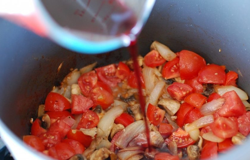 1. Этап. Каччиаторе (курица по-итальянски): 8. Нарежьте небольшими кусочками помидоры, добавьте их к грибам и влейте красное вино.