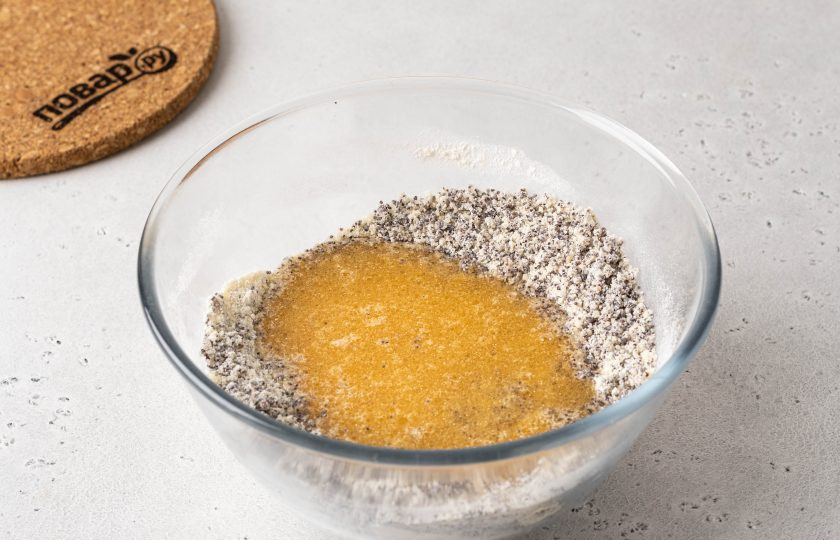 1. Этап. Постный пирог с мандаринами: Добавьте сахар и мак. Влейте жидкие ингредиенты. Перемешайте до однородности.