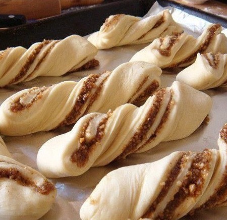 1. Stage. Walnut buns: Then twist each strip and put on a pan covered with parchment, grease with whipped egg yolk and let stand on warm for another 15 minutes.