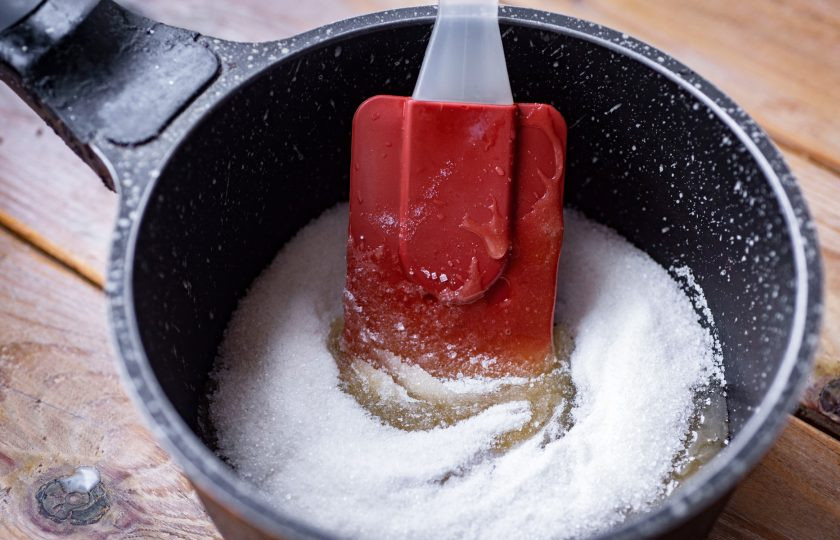 1. Этап. Башкирский чак-чак: Приготовьте медовый сироп. В сотейник выложите весь сахар и добавьте мед. На маленьком огне, постоянно помешивая ложкой, не доводя до кипения, дождитесь полного растворения сахара.