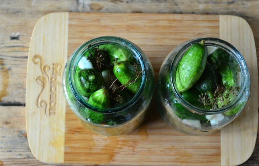 1. Этап. Малосольные огурцы хрустящие: Всю зелень ополосните под проточной водой, просушите. Сложите зелень в банки, заполните их огурчиками как можно плотнее. Обратите внимание, на дно следует класть огурчики покрупнее, а сверху помельче.