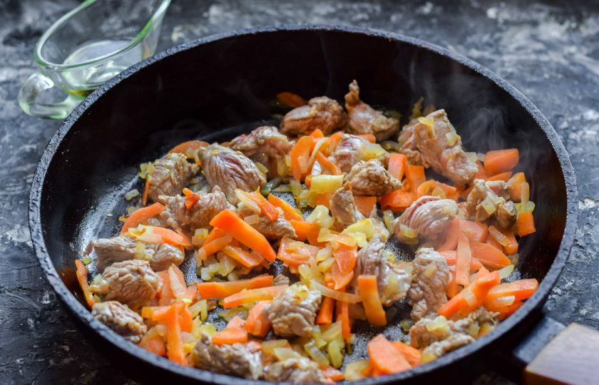 1. Этап. Плов с телятиной и карри: Сковороду прогрейте и влейте масло, жарьте морковь, лук и мясо 8-10 минут.