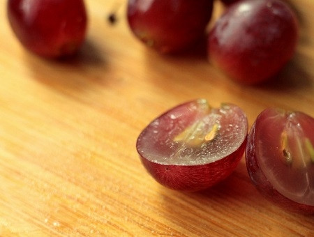 1. Этап. Салат с курицей и сельдереем: Разрезаем виноградинки пополам, удаляем косточки.