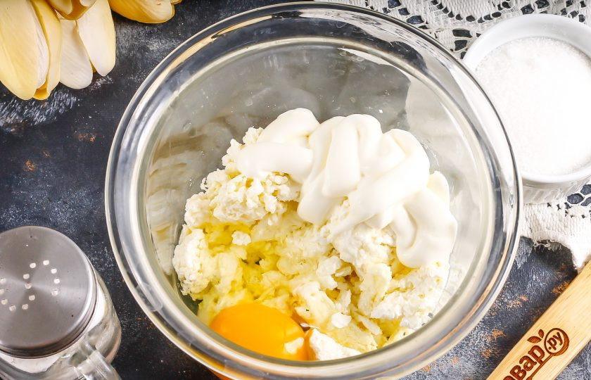 1. Этап. Сливовый чизкейк: Пока основа выпекается, выложите творог любой жирности в глубокую емкость, туда же добавьте сметану, вбейте куриное яйцо.