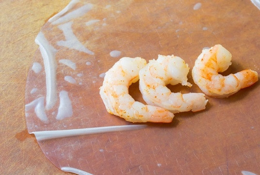 1. Этап. Вьетнамские спинг-роллы: 3. На лист выложите несколько креветок, предварительно поперчив их и добавив специи по вкусу.