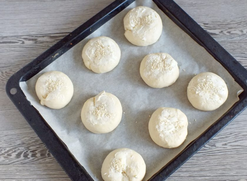 1. Этап. Булочки на рассоле: Подготовленные булочки переложите на противень застеленный пергаментом. Смажьте сливочным маслом и присыпьте кунжутом. Прикройте полотенцем и оставьте на 15 минут для подъема. После поставьте выпекаться в разогретую до 180 градусов духовку на 20-25 минут.