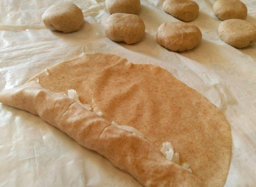 1. Этап. Лепёшки «Фатир» в духовке: Каждый пласт с луком сверните в трубочку, двигаясь от края с начинкой.