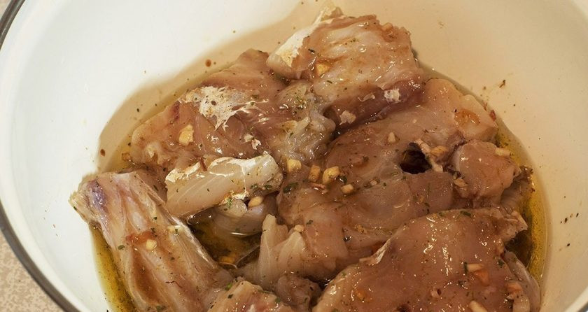 1. Этап. Пикша в духовке: Готовим маринад для рыбы. Смешиваем универсальную приправу, соль, измельченный чеснок, соевый соус, малиновый уксус и растительное масло. Перемешиваем до однородности. В маринад добавляем нарезанные стейки пикши. Накрываем крышкой и отправляем в холод на 20 минут.