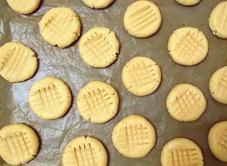 1. Этап. Простое арахисовое печенье: Сделайте из теста шарики величиной с грецкий орех и уложите на смазанный противень. Затем сделайте узор на верху при помощи зубчиков вилки надавив на верх печенья.