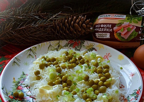 1. Этап. Салат Снежные сугробы: Посыпать зелёный горошек и рубленый зелёный лук.