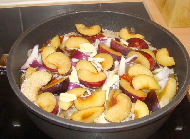 1. Этап. Баранина на кости тушеная: Затем выложите сверху баранины фрукты и овощи. Закройте крышкой, не перемешивая. Полчаса томите на медленном огне, чтобы сливы и томаты пустили сок на мясо.