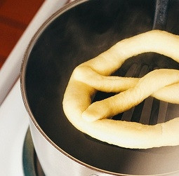 1. Этап. Немецкие брецели: 5. Доведите до кипения воду в большой кастрюле. Добавьте соду, аккуратно опускайте брецели при помощи шумовки в воду секунд на 15-20.