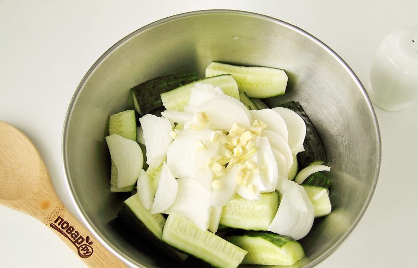 1. Этап. Салат из огурцов Дамские пальчики: Добавьте к огурцам нарезанный перьями или полукольцами лук и измельченный ножом чеснок.