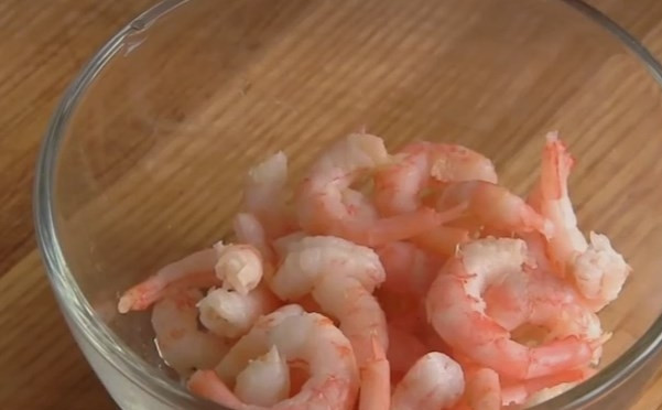 1. Этап. Слоеный салат Королевская шуба: 6. Очищенные креветки обжарьте, чтобы их вкус стал ярче. Для этого в оливковом масле обжарьте раздавленный чеснок, уберите его, отправьте креветки на сковороду и 2-3 минуты жарьте на сильном огне, помешивая. Сбрызните лимонным соком.