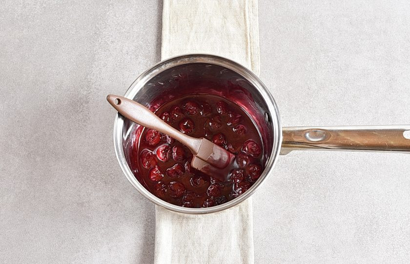 1. Этап. Торт в мультиварке: Пока торт печется и остывает, сварите вишневую начинку. Для этого смешайте размороженную вишню с соком с оставшимся сахаром и кукурузным крахмалом. Доведите до кипения при помешивании и проварите пару минут до загустения. Остудите начинку.