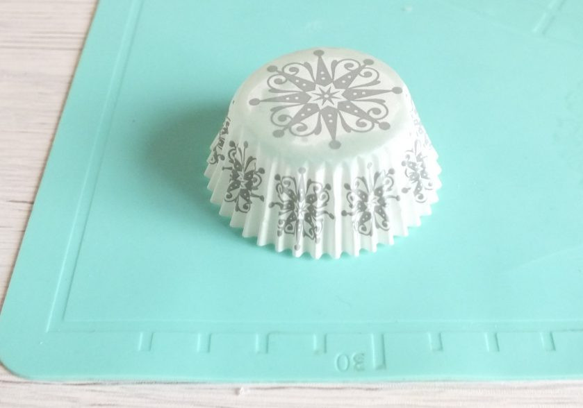 1. Этап. Корзиночки с фруктами и кремом: Подготовьте форму в которой будете выпекать. Возьмите небольшие бумажные формочки. Переверните их, чтобы донышко было вверху. Кругами из теста накройте сверху бумажные формочки и перенесите на форму для запекания или противень. Включите духовку на 180 градусов. Выпекайте 15-20 минут.