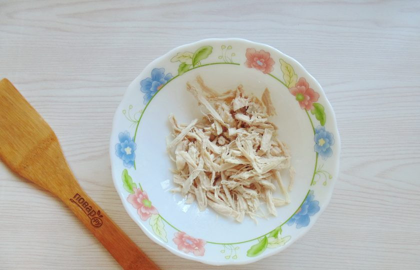 1. Этап. Салат Лиза: Мясо отварной куриной грудки разберите на волокна. Выложите в салатник.