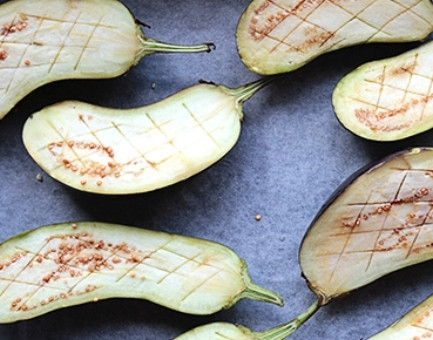 1. Этап. Запеченные баклажаны с йогуртово-чесночным соусом: 1. Помойте тщательно баклажаны, разрежьте каждый вдоль пополам. Хвостики обрезать не нужно, поскольку за них будет удобно браться, чтобы кушать баклажаны. Сделайте небольшие надрезы вдоль и поперек (получится сетка наискось).