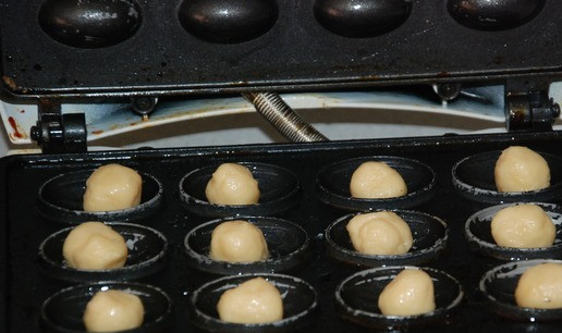 1. Этап. Печенье Орешки с шоколадом: В разогретую орешницу в каждую выемку в серединку кладем шарик теста. Орешницу закрываем.