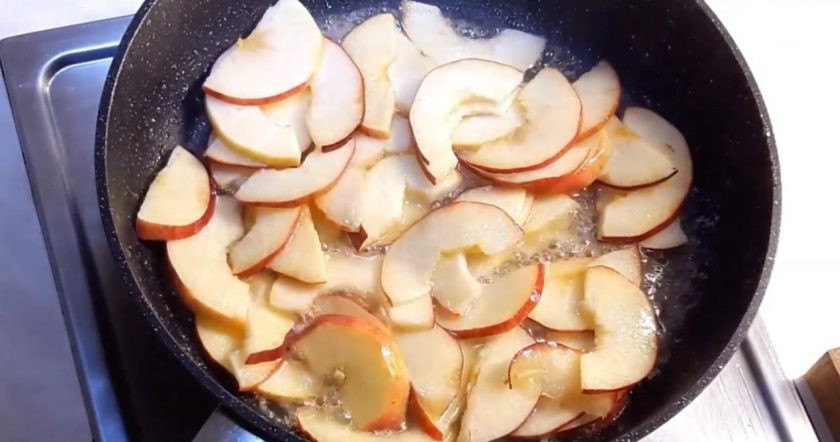 1. Этап. Пирог с яблоками по-Афински: 3. Яблоки разрежьте наполовину и удалите из них середину. Нарежьте их тонкими полосками и отправьте на сковородку, в которой разогрейте сливочное масло с сахаром. Немного подержите яблоки (до полупрозрачности) в кипящем масле.