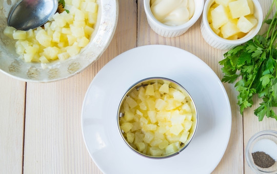 1. Этап. Салат Дамский каприз с курицей: Поверх мяса выкладываем нарезанный на мелкие кубики ананас.