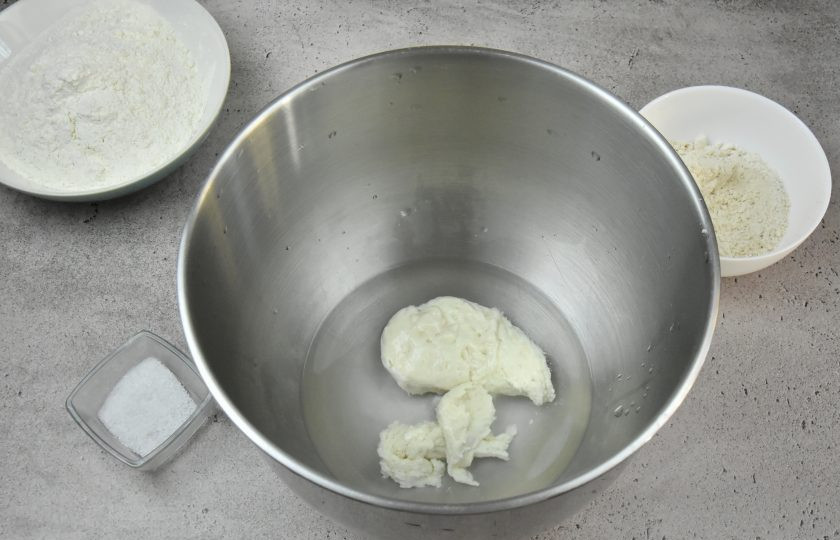 1. Этап. Ремесленный хлеб: Для приготовления теста влейте в емкость прохладную воду, переложите в нее всю опару из закваски, перемешайте.