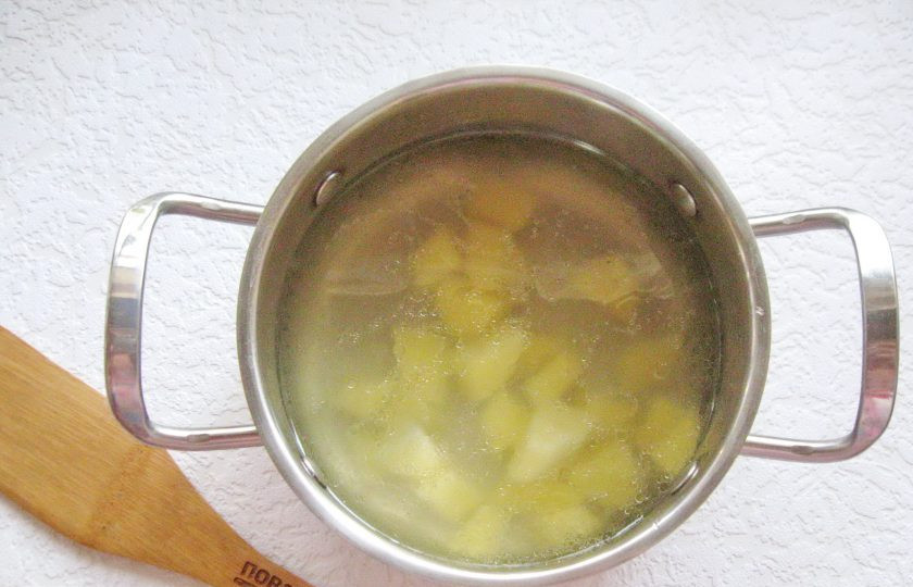 1. Этап. Куриный суп с сельдереем и рисом: Картофель очистите, ополосните, нарежьте, как на суп и выложите в кастрюлю с бульоном. Поставьте кастрюлю на средний огонь.