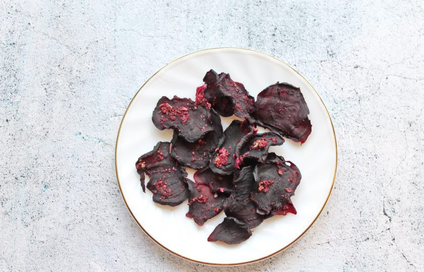 1. Этап. Вяленая свекла в духовке: Поставьте противень со свеклой в духовку, разогретую до 100 градусов, и сушите в течение 1-2 часов. Время зависит от желаемой консистенции и толщины кружочков. Снимите вяленую свеклу с пергамента, остудите и подавайте.