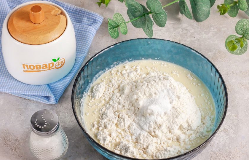 1. Этап. Оладьи с творожным сыром: Всыпьте пшеничную муку высшего сорта и разрыхлитель. Аккуратно вмешайте сухие составляющие в жидкие. Тесто должно получиться гуще, чем для обычных блинов.