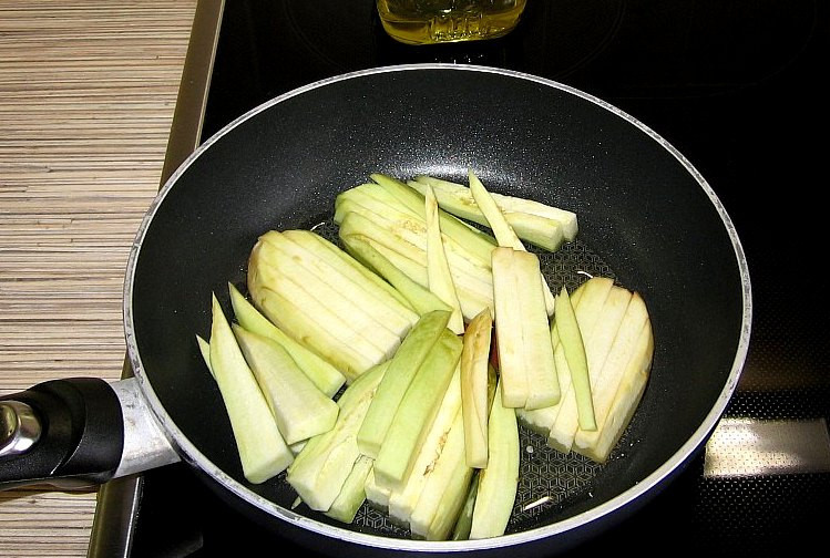 1. Этап. Рулеты из говядины в духовке: Баклажан чистим от кожуры и нарезаем брусками, наливаем на сковороду растительное масло, нагреваем его и выкладываем в масло баклажан, обжариваем до золотистого цвета. Перец очищаем от семян, разрезаем его на 4 части и также жарим в масле до золотистого цвета.