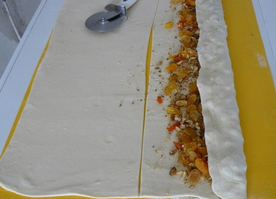 1. Этап. Рулет из сухофруктов и орехов: 4. Тесто нарежьте на несколько пластов, чтобы рулетики не были слишком высокими и быстрее пропекались. Выложите начинку на один край.