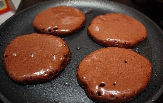 1. Этап. Шоколадные оладьи: Сковородку нужно хорошенько разогреть, добавить на нее масло. Жарить оладьи нужно на сильном огне, быстро, обжаривая с двух сторон. В процессе жарки оладьи должны подниматься и слегка разрастаться и становиться пышными. Такими они должны остаться даже после того, как остынут.