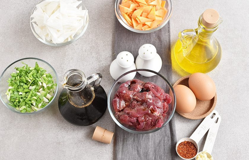 1. Этап. Корейский суп: Говядину нарежьте неширокими полосками, полейте ложкой соевого соуса, перемешайте и оставьте мариноваться минут на 10. За это время нарежьте очищенные овощи косыми ромбиками. Корейцы называют такую нарезку «лепестками ивы». Толщина нарезки не толще 4-5 мм.