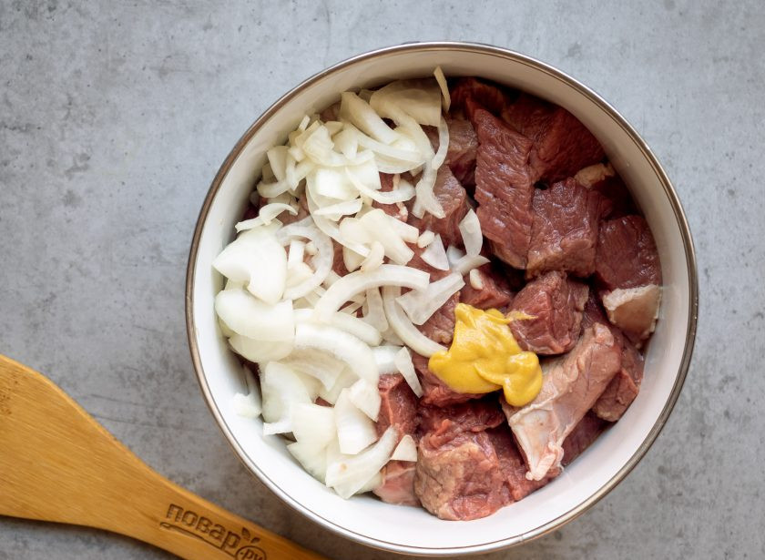 1. Этап. Лосятина с картошкой в духовке: Лосятину до приготовления рекомендуется вымочить 10-12 часов в воде или же замариновать. В данном рецепте предлагаю замариновать мясо, чтобы получить богатый вкус и аромат. Нарежьте мясо кусочками, добавьте горчицу, нарезанный полукольцами лук.