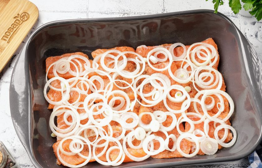 1. Этап. Форель под майонезом и сыром: Лук нарежьте тонкими колечками и выложите сверху. Так же немного посолите по вкусу.