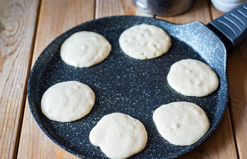 1. Этап. Панкейки с содой: Разогрейте сухую сковороду на среднем огне. Порционно выкладывайте в нее тесто. Обжарьте панкейки с двух сторон до золотистого оттенка.