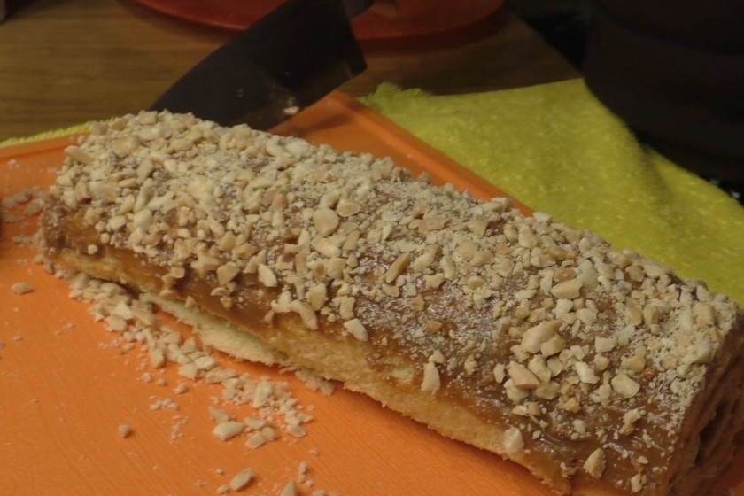 1. Этап. Ореховый рулет с вареной сгущенкой (на скорую руку): 5. Разверните рулет, смажьте его вареной сгущенкой. После чего снова сверните, сверху намажьте сгущенкой и украсьте размельченным жареным арахисом.