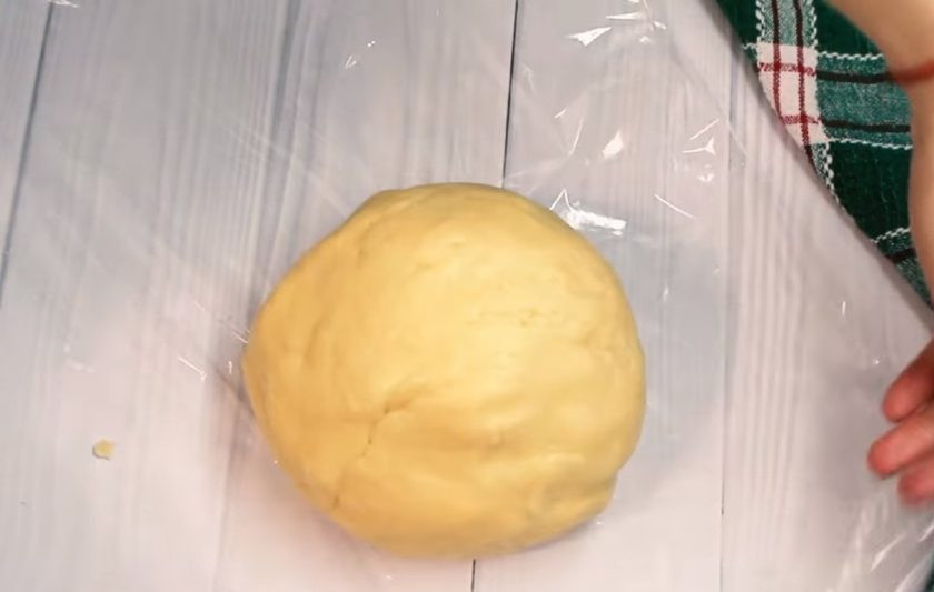 1. Этап. Пасхальное печенье в белковой глазури: 2. В отдельной емкости смешайте яйцо и молоко, слегка взбейте их венчиком и добавьте их к остальным ингредиентам. Небольшими порциями добавьте просеянную муку и замесите тесто. Заверните его в пищевую пленку и отправьте в холодильник на 1 час.