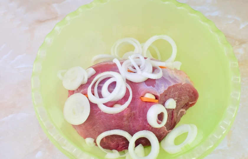 1. Этап. Мясо по-немецки: Мясо выложите в чашу. Лук очистите, нарежьте и помните руками. Обложите мясо со всех сторон, накройте чашу пищевой пленкой и оставьте на 2 часа.