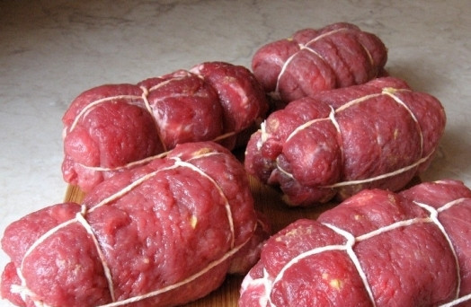 1. Этап. Говяжьи ролады: Заворачиваем мясо в плотные рулеты и обвязываем ниткой или скрепляем зубочистками, чтобы ролады не развалились.