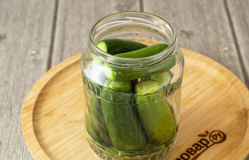 1. Этап. Соленые огурцы хрустящие: Заполните банку огурцами.