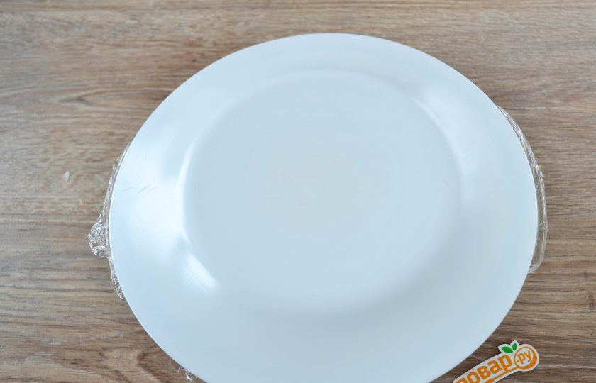 1. Этап. Салат Грибная поляна: Накройте все плоской тарелкой и аккуратно переверните миску с салатом, чтобы грибы оказались сверху.