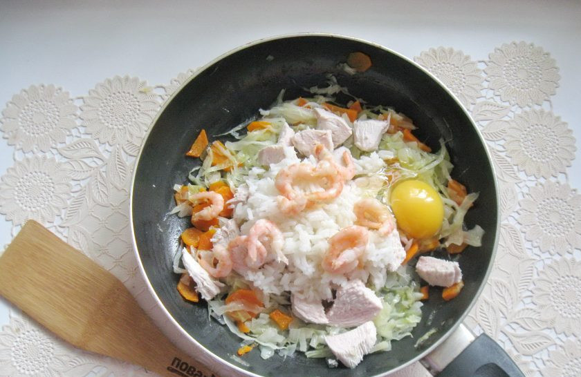 1. Этап. Рис по-сингапурски: Вбейте в сковороду с овощами, курицей, рисом и креветками сырое яйцо. Посолите и поперчите по вкусу, перемешайте и прогрейте все ингредиенты еще 5 минут.
