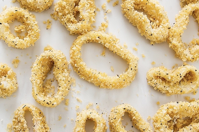 1. Этап. Кальмар в духовке: В небольшой емкости взбейте 2 яйца. Отставьте пока эту мисочку в сторону. В две отдельные мисочки высыпьте муку и сухари. К сухарям добавьте смесь итальянских сушеных трав и перемешайте. Теперь каждое кольцо кальмара сначала обваляйте в муке (постукивая о край тарелочки, чтобы лишнее обсыпалось), затем обмакните в яйцо (тоже постукивая) и, наконец, в сухари. Выложите на противень.