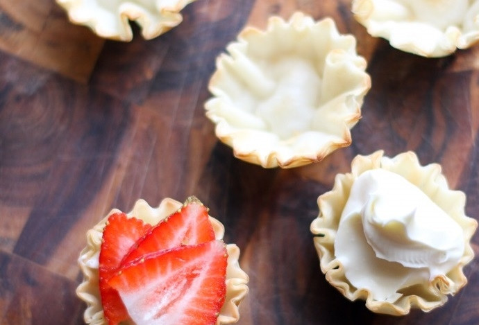 1. Этап. Тарталетки с сыром и клубникой: 3. Нарежьте клубнику тонкими пластинками и уложите поверх сыра.